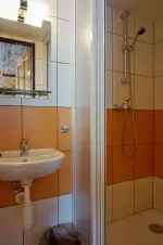 koupelna se sprchovým koutem, umyvadlem a WC u ložnice s dvojlůžkem, lůžkem a patrovou postelí v podkroví