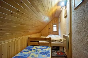 ložnice dvojlůžkem a dětskou postelí v podkroví