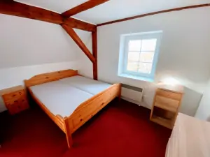 ložnice s dvojlůžkem a opticky odděleným koutem s dětskou patrovou postelí  a dětským lůžkem