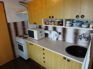opticky oddělený kuchyňský kout je plně vybavený pro vaření a stolování 4 osob