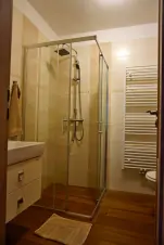 menší koupelna se sprchovým koutem, umyvadlem, WC a pračkou v přízemí