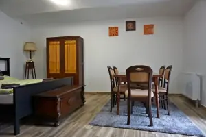 ložnice s dvojlůžkem, stolem a židlemi