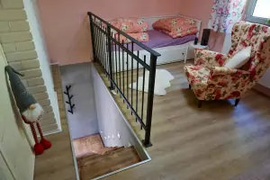 schody do podkroví a otevřená průchozí ložnice s plnohodnotnou rozkládací postelí pro 2 osoby