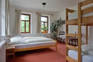 ložnice s dvojlůžkem, patrovou postelí a přistýlkou (rozkádací křeslo) v apartmánu v prvním patře