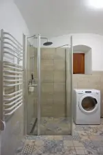 koupelna se sprchovým koutem, umyvadlem, WC a pračkou