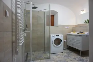 koupelna se sprchovým koutem, umyvadlem, WC a pračkou