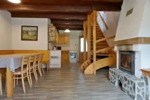 pravá část chalupy - obývací pokoj s krbem, sedacím a jídelním prostorem a kuchyňským koutem
