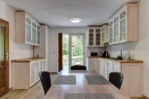 suterén - obytný pokoj s kuchyňským a jídelním koutem, krbovými kamny, sedací soupravou a TV