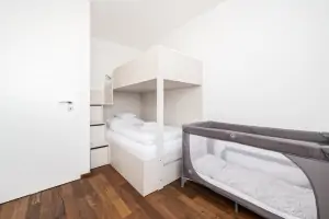 ložnice s patrovou postelí, dětskou postelí (vysouvací z patrové postele) a s dětskou postýlkou