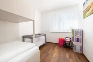 ložnice s patrovou postelí, dětskou postelí (vysouvací z patrové postele) a s dětskou postýlkou