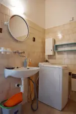 koupelna se sprchovým koutem, pračkou, umyvadlem a dveřmi odděleným WC