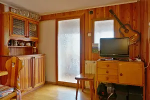 obytný pokoj s rozkládacím gaučem, jídelním koutem a TV