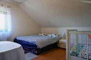 ložnice se 2 lůžky a dětskou postýlkou v podkroví