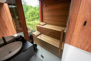 prosklená finská sauna z cedrového dřeva s výhledem z chaty