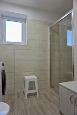 koupelna se sprchovým koutem, umyvadlem, WC a  pračkou