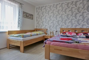 ložnice s dvojlůžkem, lůžkem a dětskou postýlkou v podkroví