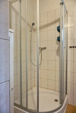 koupelna se sprchovým koutem, umyvadlem a pračkou se sušičkou