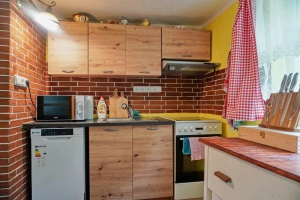 kuchyně s jídelním koutem, pohovkou a kamny