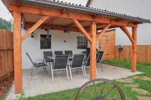 zastřešený altán se zahradním nábytkem a plynovým grilem