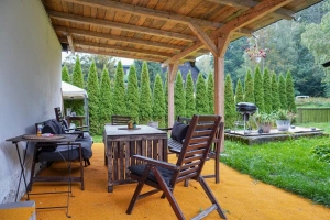 zastřešená pergola se zahradním nábytkem a gril