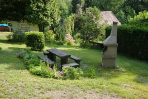 před chatou je k dispozici venkovní posezení a zahradní krb