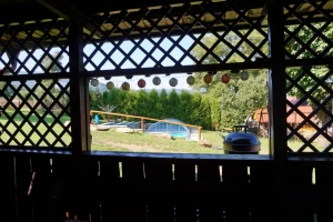 pohled k bazénu od zastřešeného venkovního posezení