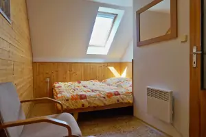 ložnice s dvojlůžkem a dětskou postelí v horním patře
