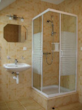 Koupelna je vybavena vanou, sprchovým koutem, WC a umyvadlem