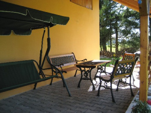 Terasa chalupy Zátoň se zahradním nábytkem a houpací lavicí