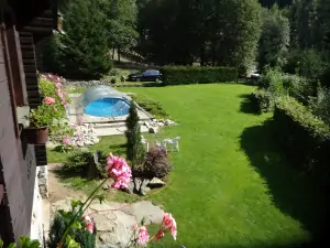 pohled z terasy chaty k bazénu a do zahrady