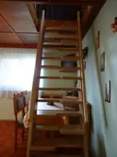 z obytné kuchyně vedou příkré schody do podkrovní ložnice