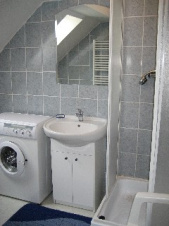 Koupelna v 1. patře je vybavena sprchovým kouem, WC, umyvadlem a pračkou