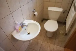 koupelna se sprchovým koutem, umyvadlem a WC u malé kuchyňky
