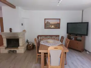 krb, stůl, židle a TV v obytné kuchyni