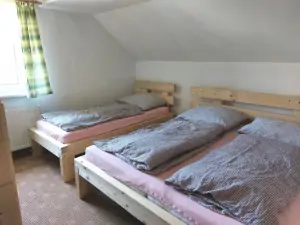 ložnice s dvojlůžkem, lůžkem a patrovou postelí v prvním patře