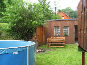 Za chalupu je k dispozici zahradní bazén a venkovní posezení
