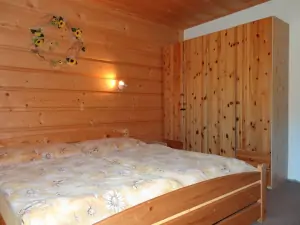 ložnice s dvojlůžkem a patrovou postelí v podkroví
