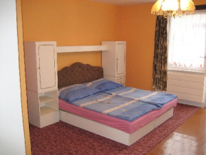 Manželská postel v obytné místnosti
