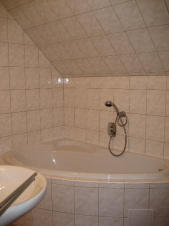 Koupelna je vybavena rohovou vanou, sprchovým koutem, WC a umyvadlem