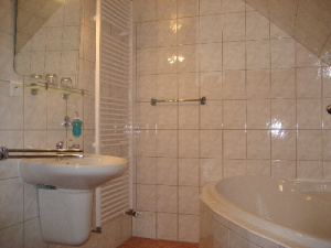 Koupelna je vybavena rohovou vanou, sprchovým koutem, WC a umyvadlem