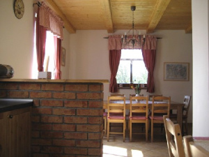 Pohled z kuchyňského koutu přes barový pult k jídelnímu stolu