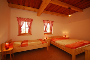 Ložnice s manželskou postelí a lůžkem v podkroví chalupy