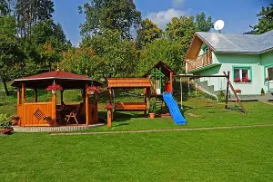 Na zahradě se nachází altán s venkovním posezením a dětský koutek