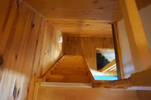 z obytného pokoje vedou příkré schody do podkrovní ložnice