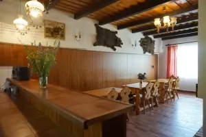 společenská místnost s jídelním prostorem, krbem a barovým pultem