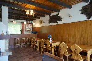 společenská místnost s jídelním prostorem, krbem a barovým pultem