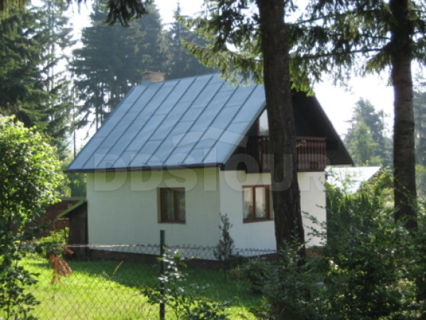 Pohled z ulice - chata leží na oplocené zahradě