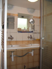 Koupelna je vybavena 2 umyvadly a sprchovým koutem