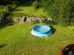 pohled na zahradu se zahradním bazénem (průměr 3 m), venkovním posezením, přenosným grilem a ohništěm 
