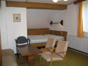 Ložnice s manželskou postelí, sedacím koutem a TV